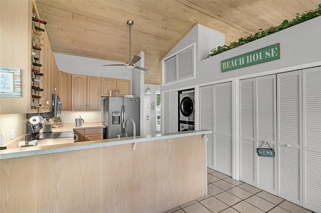 a kitchen with stainless steel appliances kitchen island granite countertop a refrigerator and a sink