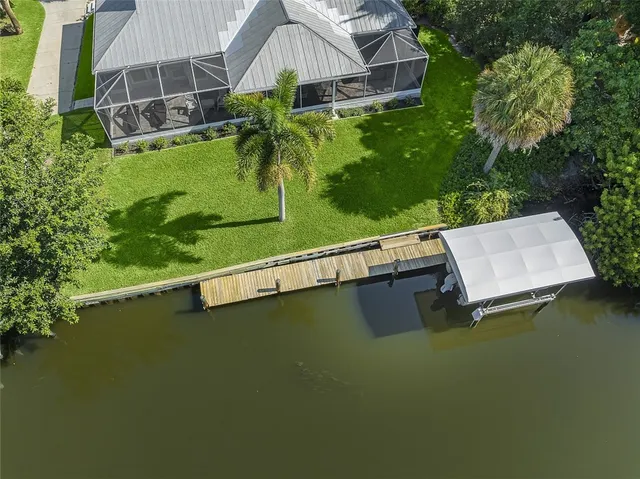 an aerial view of a house with swimming pool garden and trees