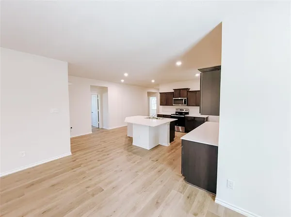 a view of kitchen with wooden floor and electronic appliances