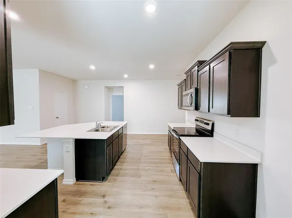 a kitchen with stainless steel appliances a sink stove and cabinets