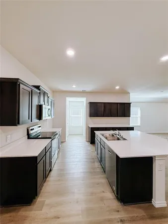 a large kitchen with stainless steel appliances a stove and a refrigerator
