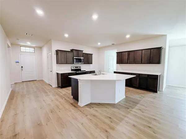 a large kitchen with a center island stainless steel appliances and cabinets