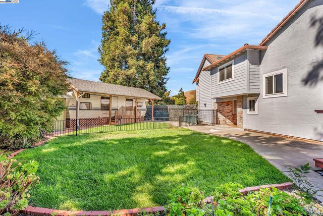 a view of a backyard with plants and brick wall
