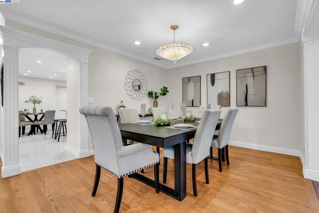 a kitchen with a dining table chairs and white cabinets