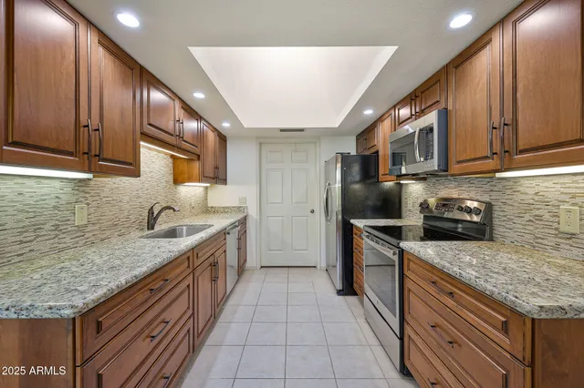 an empty room with chandelier fan and windows