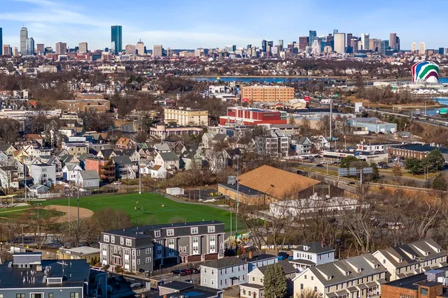 a front view of building with an entrance and flowers