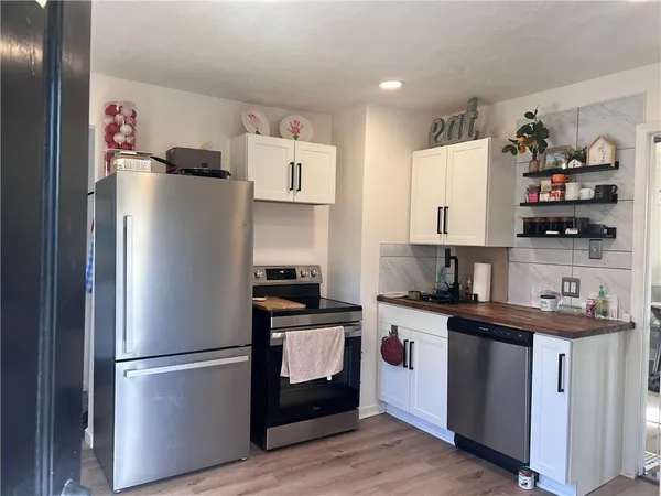 a kitchen with stainless steel appliances a refrigerator and a stove top oven