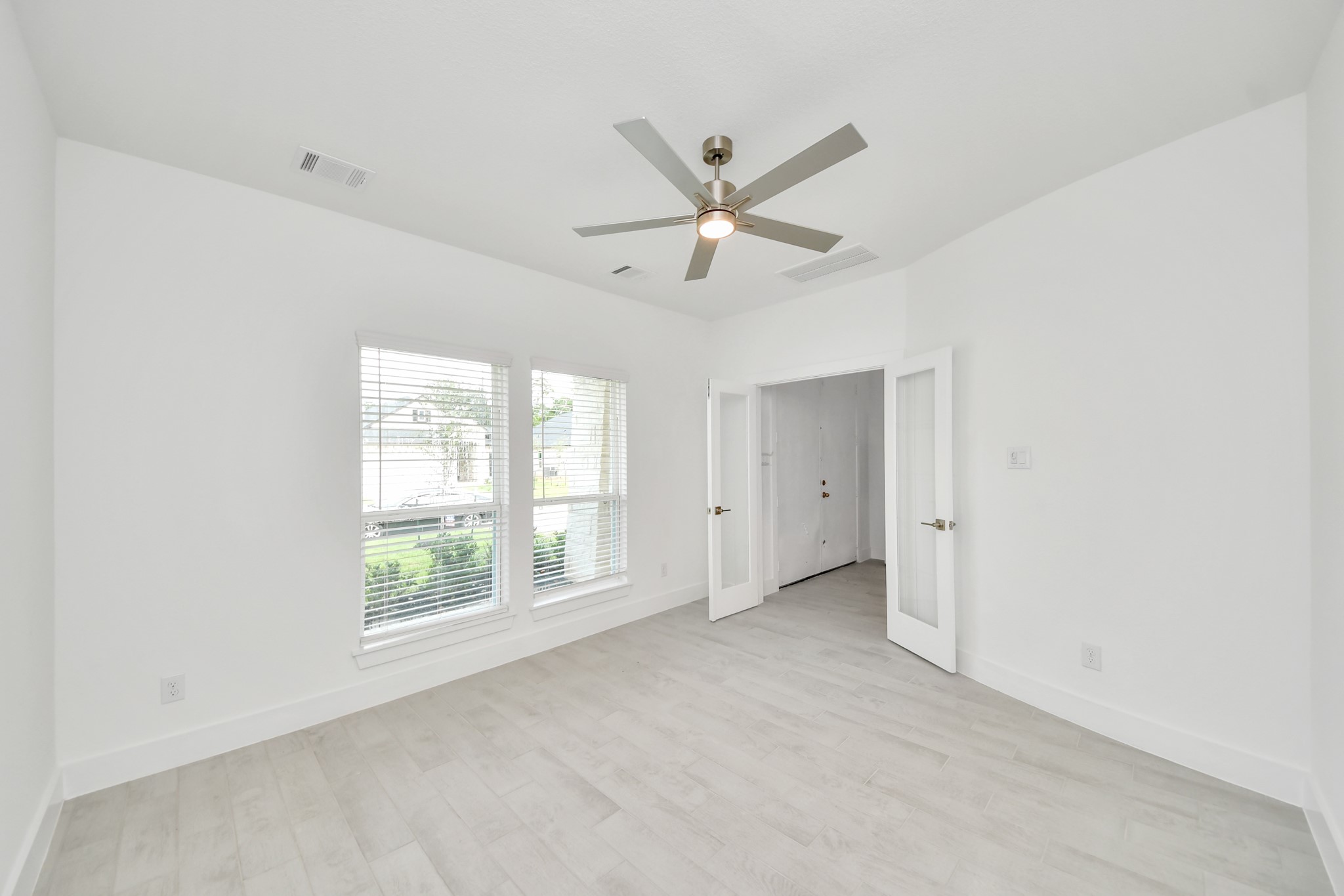 3106 Native Spg Drive Spring, TX 77373 - Photo 7 of 47 Experience the perfect blend of sophistication and warmth in this home office, boasting elegant wood-look tile flooring and flooded with natural light from expansive windows and French doors.