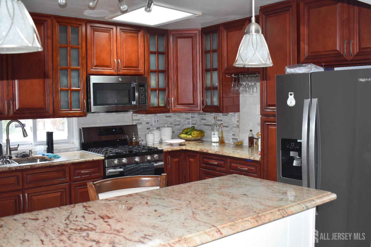 193-193 McFarlane Road Colonia, NJ 07067 - Photo 2 of 7 a kitchen with granite countertop a stove top oven microwave and cabinets