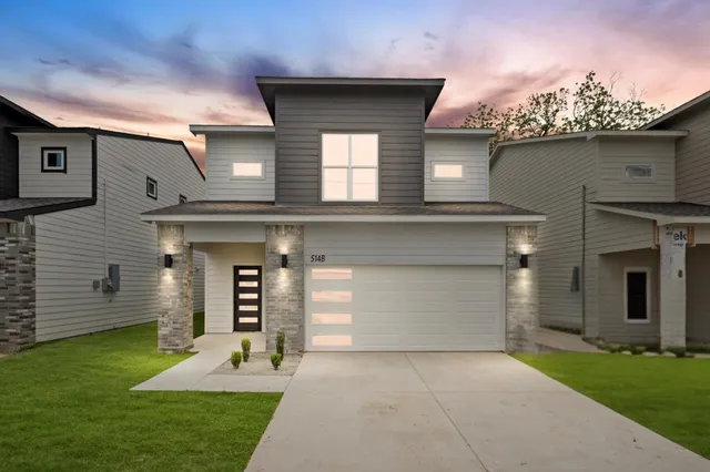 a front view of a house with a yard and garage
