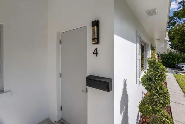 a living room with stainless steel appliances furniture a clock and a lamp