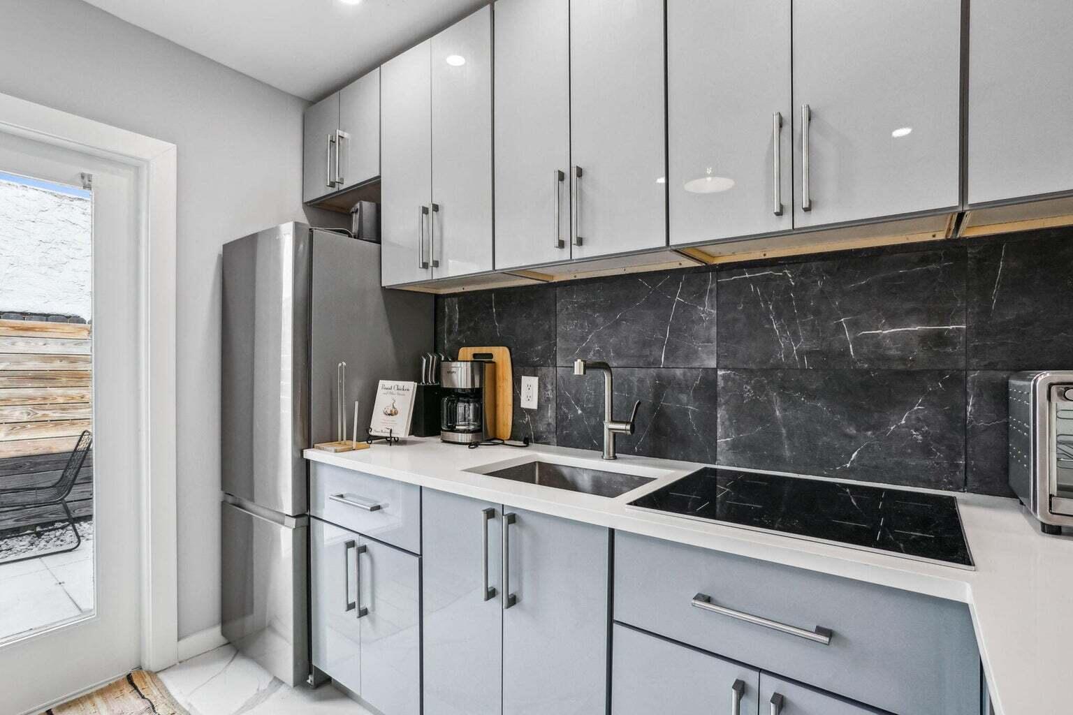 711 Southeast 2nd Street, Unit 4 Delray Beach, FL 33483 - Photo 6 of 23 a kitchen with stainless steel appliances white cabinets and a sink