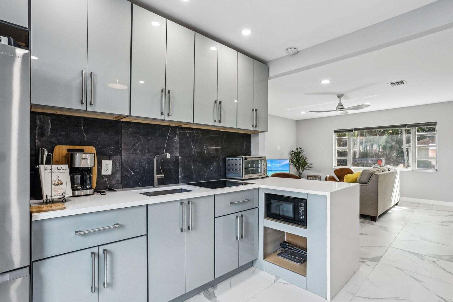 711 Southeast 2nd Street, Unit 4 Delray Beach, FL 33483 - Photo 7 of 23 a kitchen with a sink dishwasher stove and cabinets