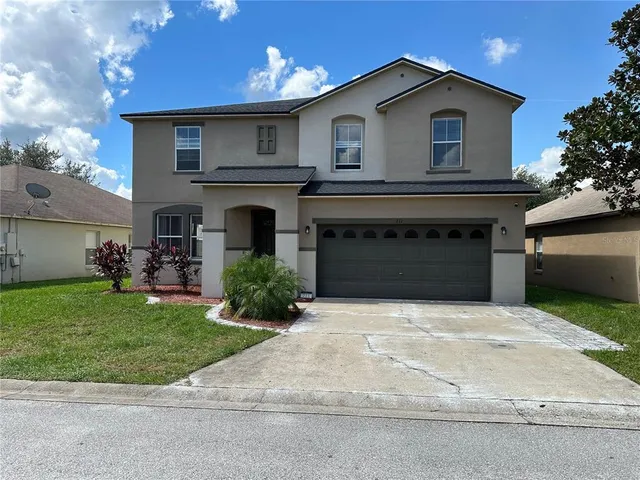 a front view of a house with a yard and garage