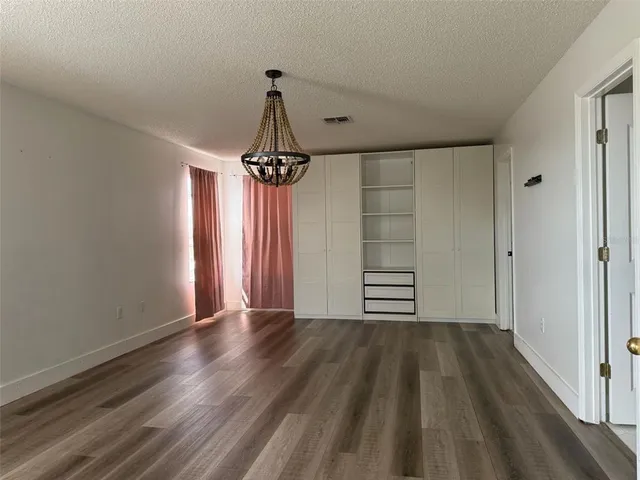 a view of a room with wooden floor closet and windows
