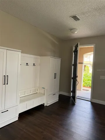 a view of an empty room with wooden floor and window