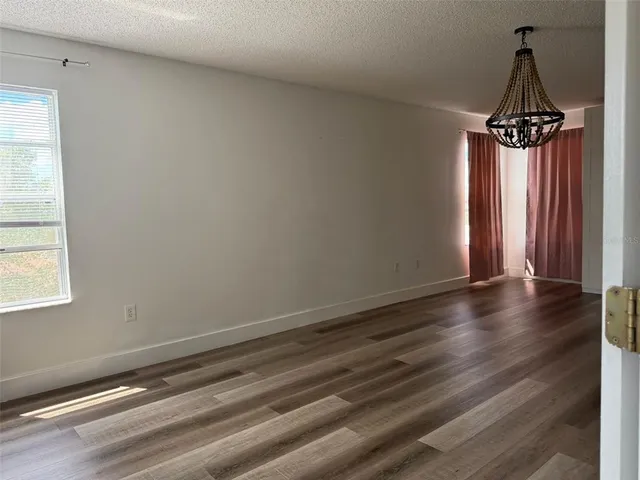 a view of a livingroom with wooden floor and a window