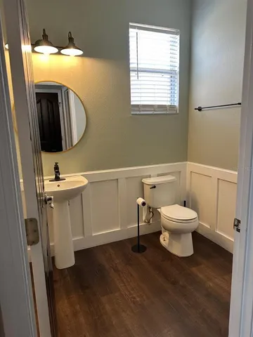 a large open kitchen with stainless steel appliances a wooden floor a large window and a sink