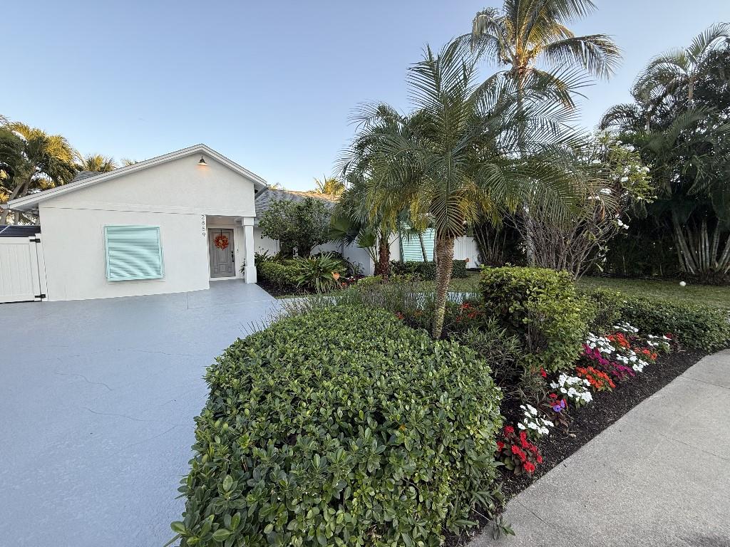 a view of a house with a yard and potted plants