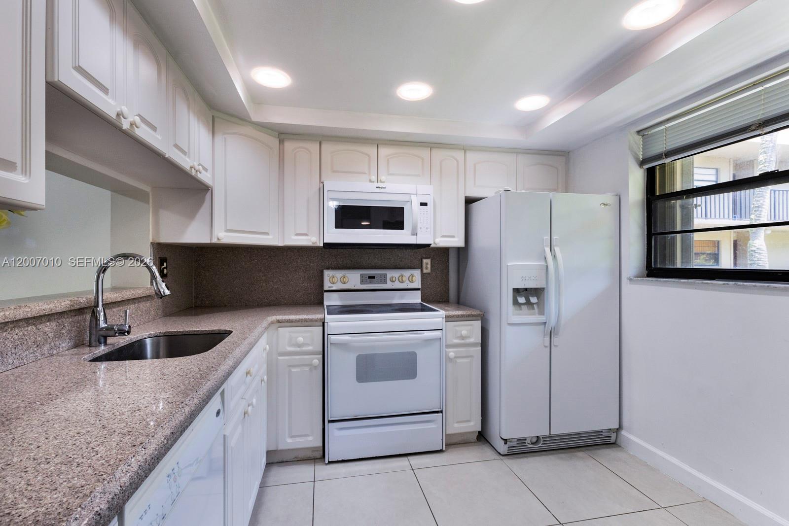10855 Southwest 112th Avenue, Unit 211 Miami, FL 33176 - Photo 20 of 23 a kitchen with stainless steel appliances granite countertop a sink stove and refrigerator