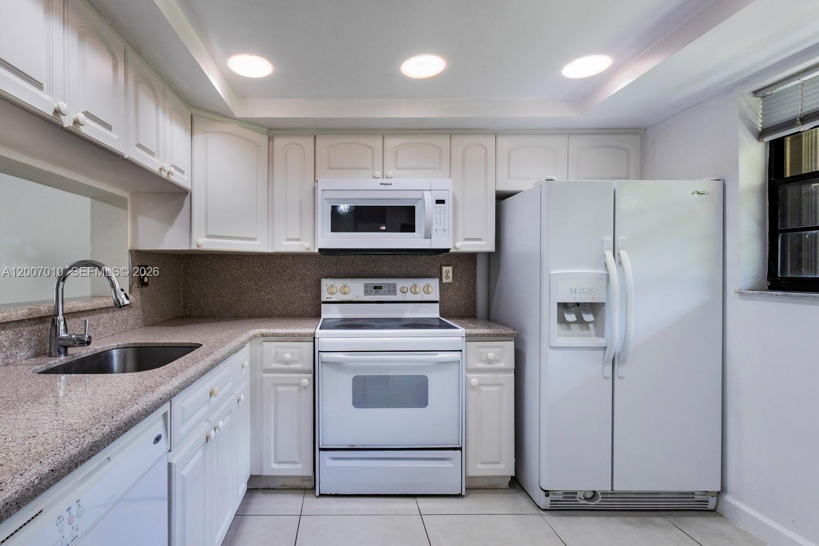 10855 Southwest 112th Avenue, Unit 211 Miami, FL 33176 - Photo 2 of 23 a kitchen with white cabinets and stainless steel appliances
