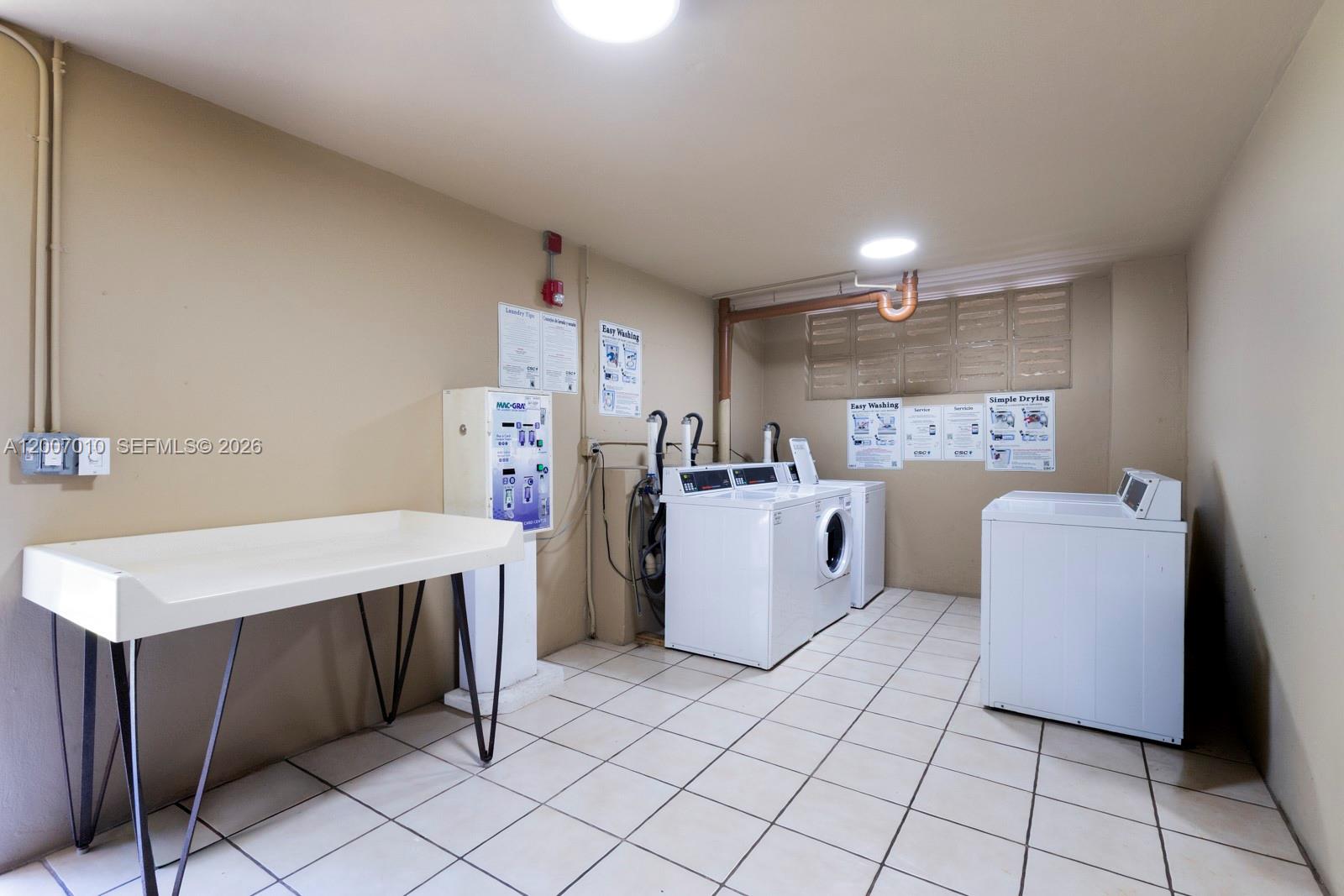 10855 Southwest 112th Avenue, Unit 211 Miami, FL 33176 - Photo 21 of 23 a utility room with cabinets washer and dryer
