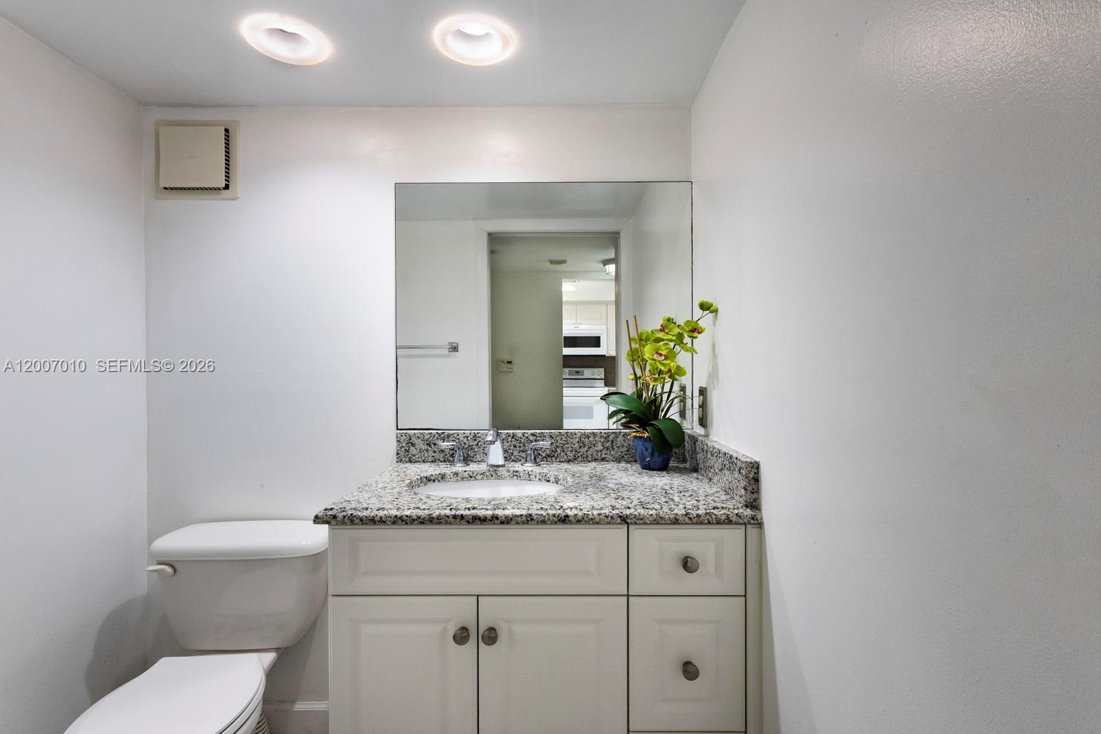 10855 Southwest 112th Avenue, Unit 211 Miami, FL 33176 - Photo 4 of 23 a bathroom with a granite countertop sink vanity mirror and toilet