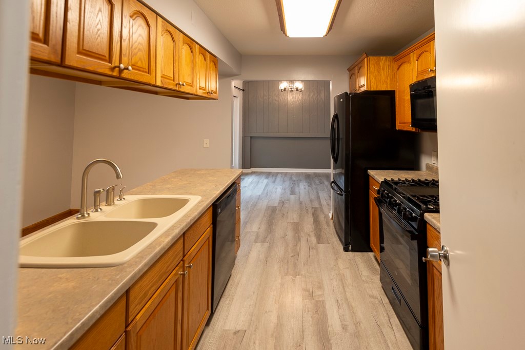 11819 Sheldon Road Mantua, OH 44255 - Photo 13 of 46 Kitchen featuring sink, black appliances, and light luxury vinyl plank floors
