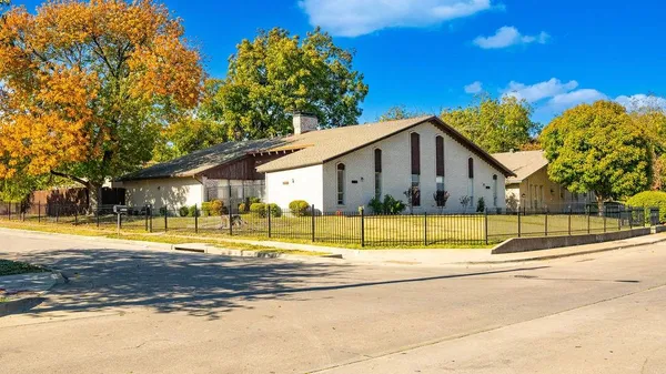 a view of yellow house with a swimming pool