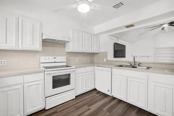a kitchen with granite countertop white cabinets and white appliances