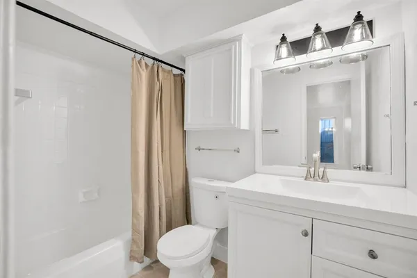 a bathroom with a sink a toilet a mirror and shower