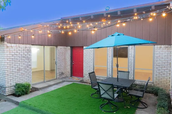 a backyard of a house with table and chairs