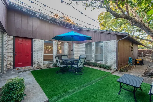 a view of backyard with seating space and wooden fence