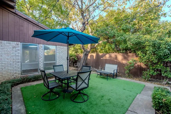 a view of table and chairs under an umbrella