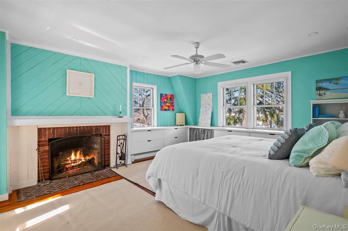 525 Milton Road Rye, NY 10580 - Photo 17 of 31 Bedroom with ceiling fan, multiple windows, and a fireplace,