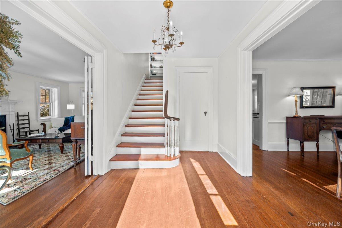 525 Milton Road Rye, NY 10580 - Photo 5 of 31 Entry hall featuring a chandelier, hardwood floors, and crown molding