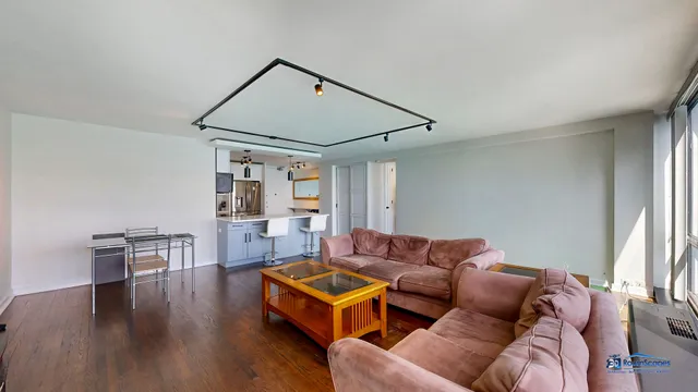 a living room with furniture a table and wooden floor