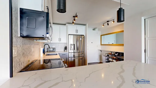 a kitchen with stainless steel appliances kitchen island granite countertop a refrigerator and a stove top oven