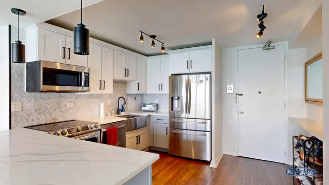 a kitchen with stainless steel appliances a refrigerator sink and microwave
