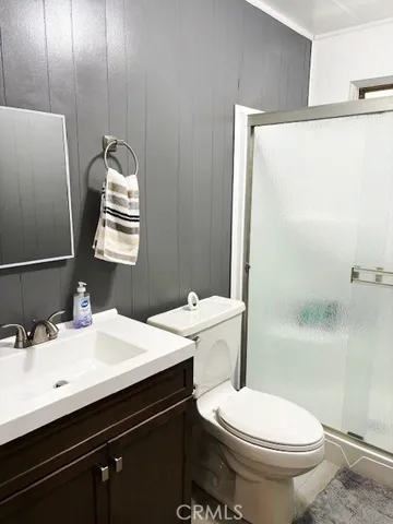 a bathroom with a sink a toilet a mirror and shower