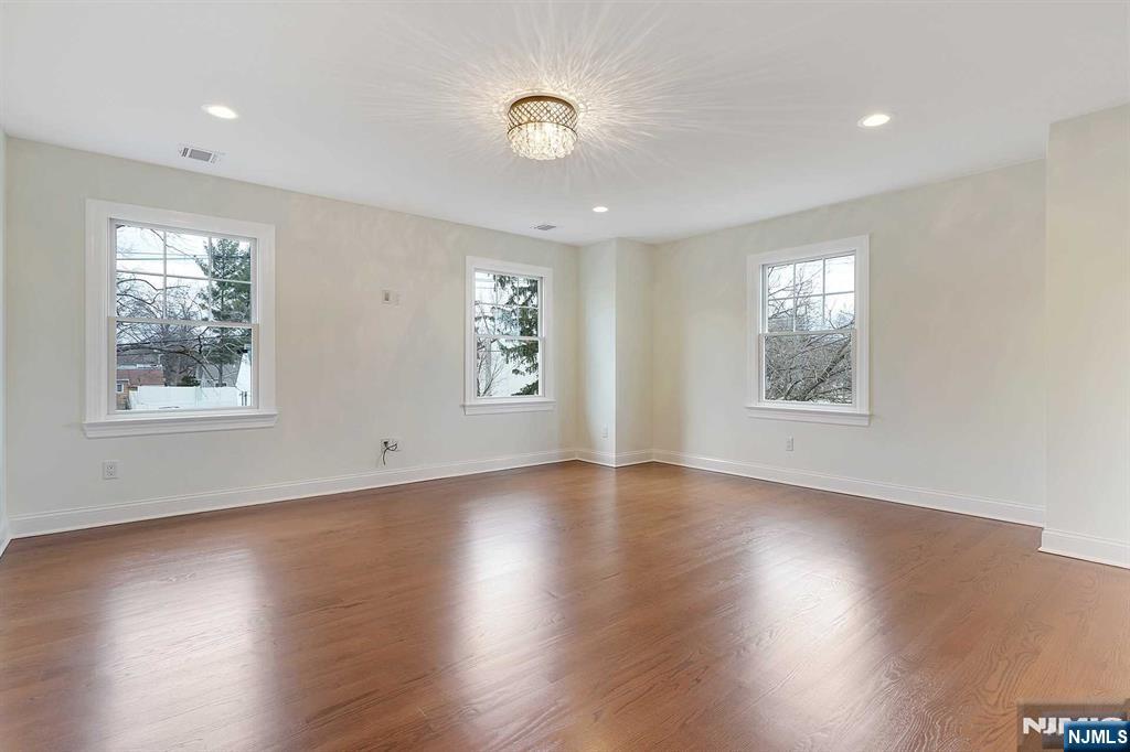 582 Green Valley Road Paramus, NJ 07652 - Photo 12 of 25 a view of an empty room with wooden floor and a window