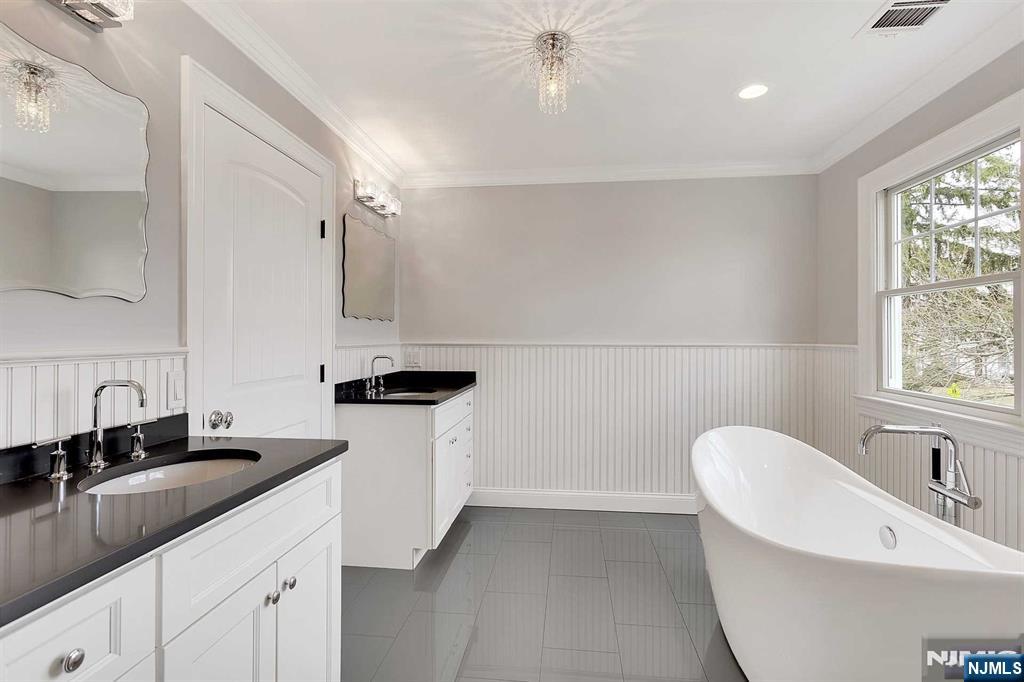 582 Green Valley Road Paramus, NJ 07652 - Photo 15 of 25 a bathroom with a double vanity sink and a bathtub