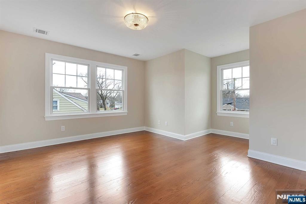 582 Green Valley Road Paramus, NJ 07652 - Photo 16 of 25 a view of an empty room with wooden floor and a window