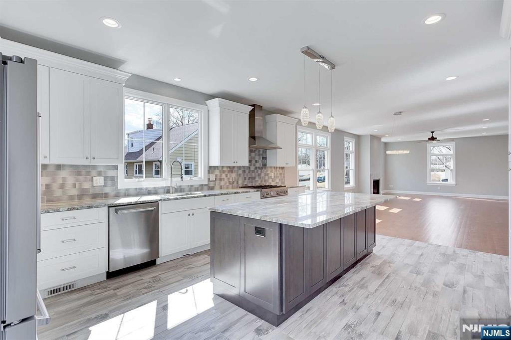 582 Green Valley Road Paramus, NJ 07652 - Photo 7 of 25 a kitchen with stainless steel appliances granite countertop a sink counter space cabinets and a large window