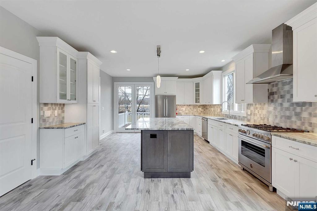 582 Green Valley Road Paramus, NJ 07652 - Photo 9 of 25 a kitchen with white cabinets and wooden floor