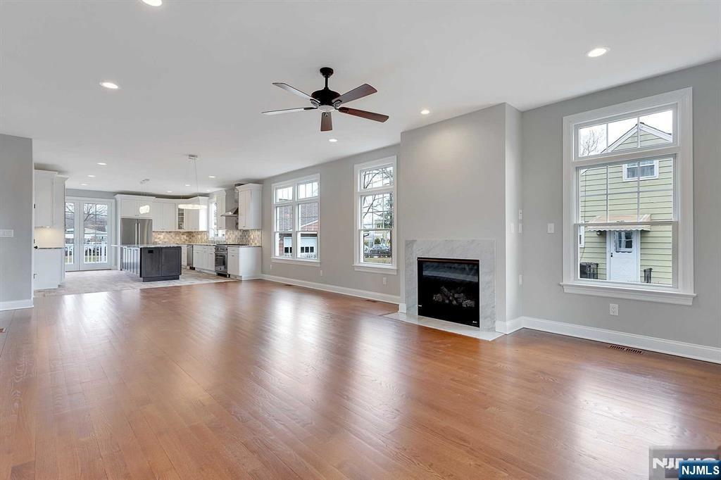 582 Green Valley Road Paramus, NJ 07652 - Photo 10 of 25 an empty room with fireplace wooden floor and windows