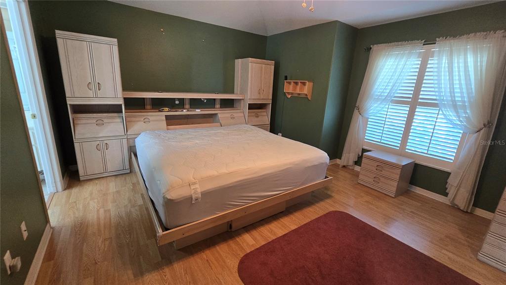 6501 Borg Street Leesburg, FL 34748 - Photo 21 of 59 a bedroom with a bed and wooden floor