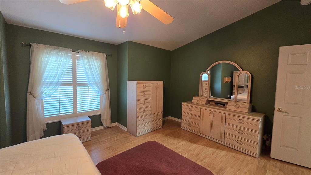 6501 Borg Street Leesburg, FL 34748 - Photo 23 of 59 a bedroom with a bed and a mirror on dresser