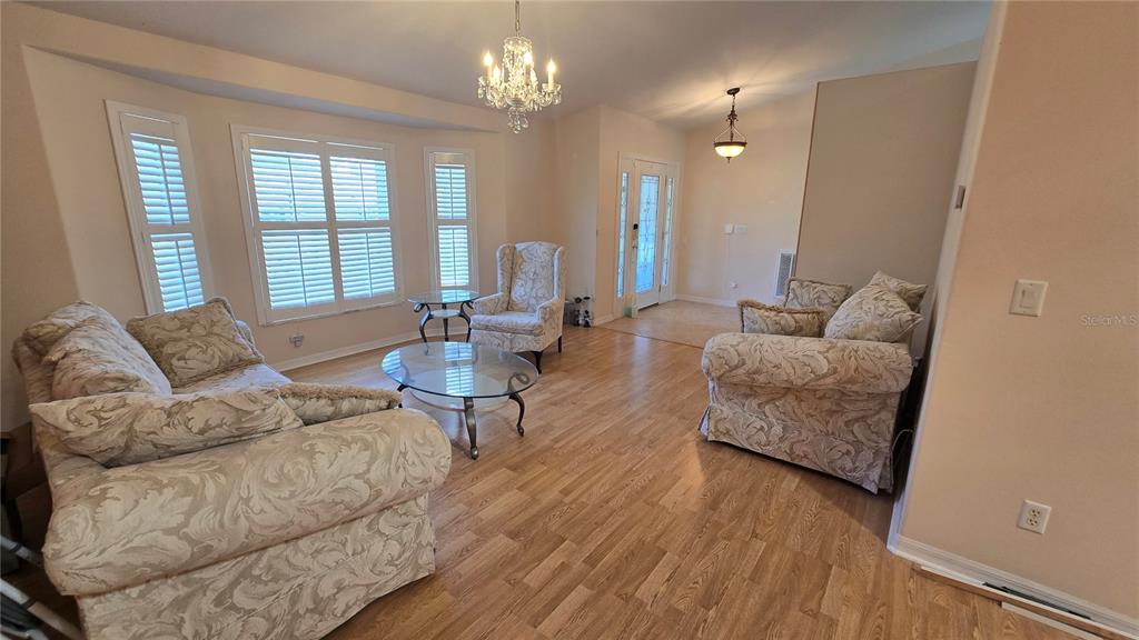 6501 Borg Street Leesburg, FL 34748 - Photo 5 of 59 a living room with furniture dining area and a chandelier