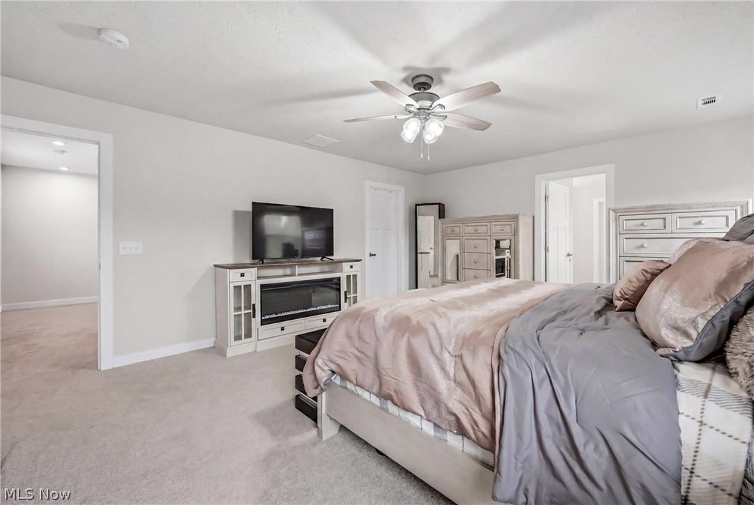 5358 Walnut Rdg Lane Sheffield Lake, OH 44054 - Photo 22 of 50 Carpeted room featuring a ceiling fan with integrated lighting, a built-in media console with an electric fireplace, and neutral wall paint